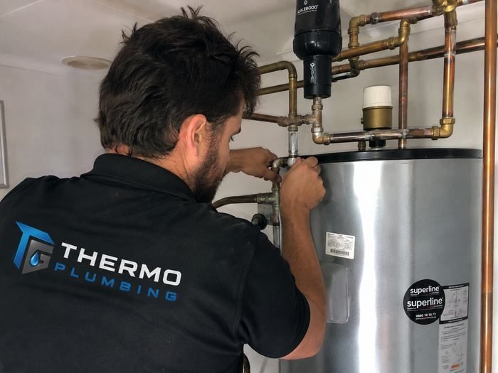 Thermo Plumbing technician adjusting a pressure control valve on an indoor geyser during a repair callout in Blouberg, Cape Town